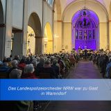 Kirchenraum mit Zuschauern rechts und links, einem Mittelgang an deren Ende das LPO NRW zu sehen ist